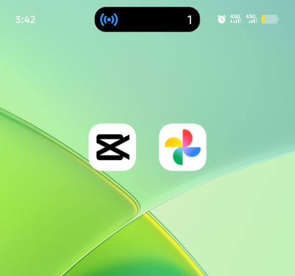 Android home screen featuring the CapCut app icon side-by-side with the Google Photos app icon on a green abstract background.